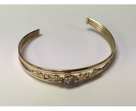 An unmarked bangle set with amethyst coloured stones weight 6.5g