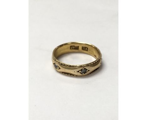 An 18ct band ring set with six diamonds. Weighing approximately 4g and measuring approximately between ring sizes n and o.