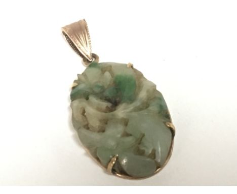 A vintage circa 1920/30 carved jade oval pendent set indistinctly marked 585. 3cm.