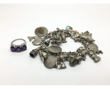 A silver charm bracelet and a ring set with amethyst coloured stones.