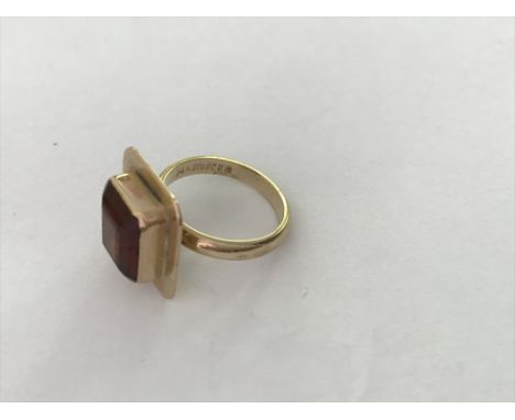 A cocktail ring inset with a ruby coloured stone .