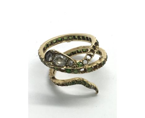 An unmarked 18k gold snake ring set with five diamonds to the head and emeralds to the body, approx 5g.