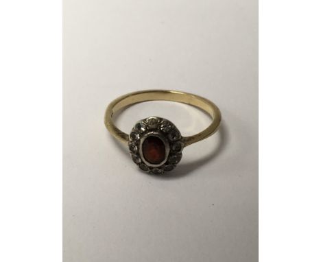 A 9 ct gold ring inset with  central ruby surrounded by diamonds.