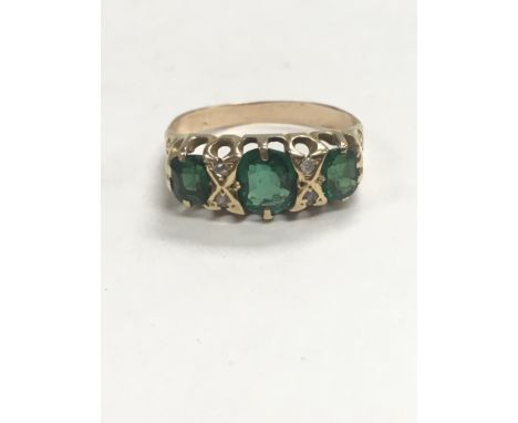 An antique 18ct gold ring set with diamonds and green stones that are possibly emeralds. Approximate ring size is O.