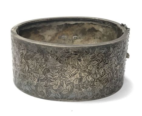 A silver bangle with a leaf print design. Weighing approximately 34.5g.