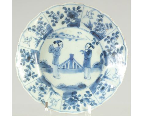 A CHINESE KANGXI BLUE AND WHITE PORCELAIN DISH, painted with figures and panels of flora, 14cm diameter.