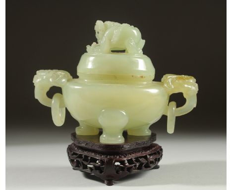 A CARVED JADE KORO AND COVER on a fitted wooden stand, with drop ring twin handles and carved foo dog finial to the cover, 14
