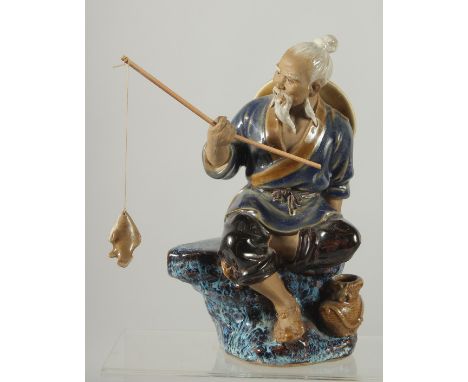 A CHINESE SHIWAN GLAZED POTTERY FIGURE OF A FISHERMAN, 19cm high.