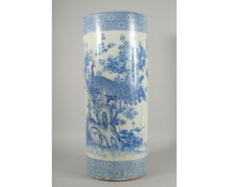 A CHINESE BLUE AND WHITE PORCELAIN WALKING STICK STAND, decorated with a peacock and native flora, 60.5cm high.