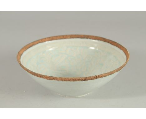 A CHINESE CELADON GLAZE CARVED POTTERY BOWL, with raised foliate decoration to the interior, 18cm diameter.