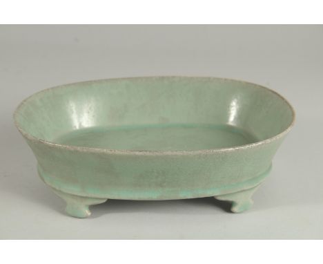 A CHINESE CELADON GLAZE OVAL-FORM PLANTER, raised on four feet, 22.5cm long.