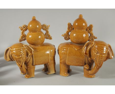 A PAIR OF CHINESE YELLOW GLAZE POTTERY ELEPHANTS, each approx. 22cm long.
