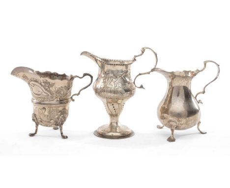 THREE SILVER MILK JUGS, comprising George III baluster jug on three feet, base engraved with cursive initial 'M', 10.2cms (h)