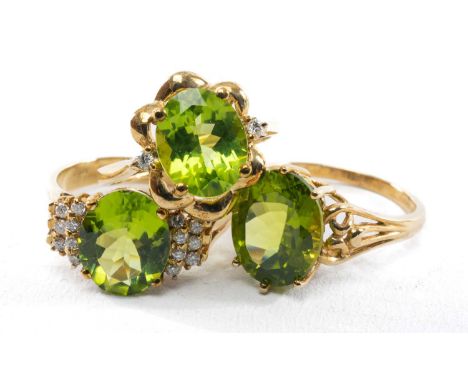 THREE 9CT PERIDOT DRESS RINGS, all mounted with oval cat stones, two the diamond shoulders, tot gross wt 10.0g (3)Provenance: