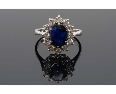18CT WHITE GOLD & PLATINUM SAPPHIRE & DIAMOND CLUSTER RING, the central oval sapphire (9 x 7mms approx.) within border of twe