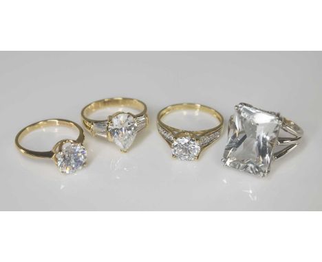 FOUR 14CT COLOURLESS GEMSTONE RINGS, comprising solitaire, solitaire with shoulder accents, large emerald cut solitaire, and 