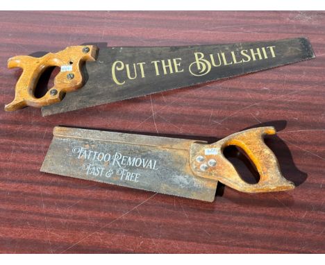 2 vintage saws with advertising stickers.