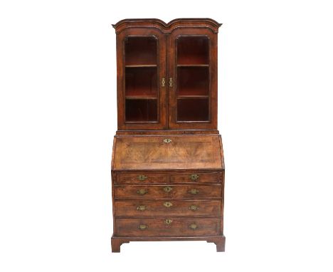 A George II Walnut, Crossbanded and Featherbanded Bureau Bookcase, circa 1730, the moulded cornice above glazed doors enclosi