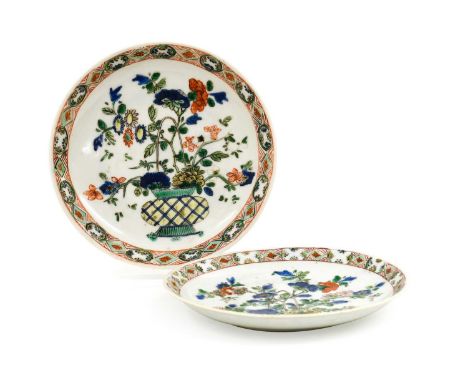 A Pair of Chinese Porcelain Saucers, Kangxi, painted in famille verte enamels with baskets of flowers within a panelled borde