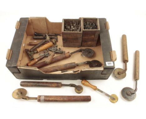 A quantity of bookbinders tools comprising three line rolls and four decorative rolls, four decorative stamps and two sets of