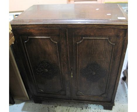 Early 20th Century oak two door, blind panelled, carved cupboard on bracket feet.(B.P. 24% incl. VAT)