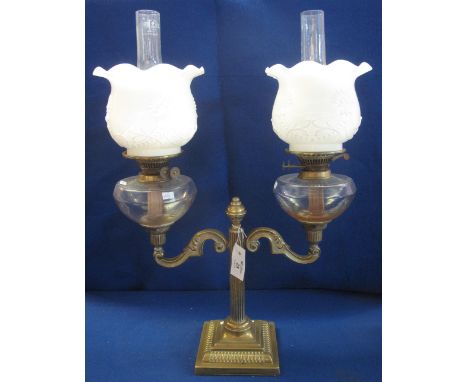 Brass double oil lamp with scrolled arms, reeded pedestal and beaded square base, a pair of brass double burner oil lamps wit