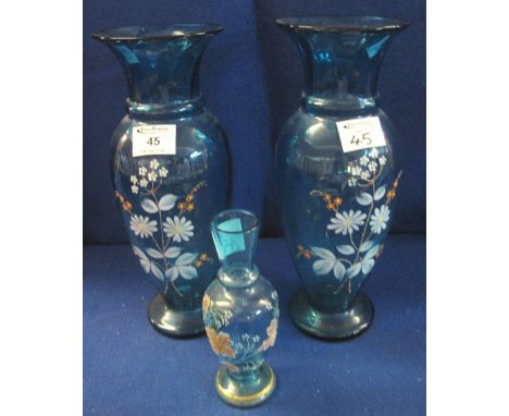 Pair of blue glass baluster shaped vases with painted enamel floral decoration, early 20th Century, together with another sim