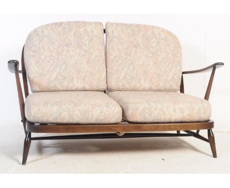 Ercol - Windsor - A mid 20th century beech and elm Ercol sofa. The sofa having shaped top rail over spindle supports with sea