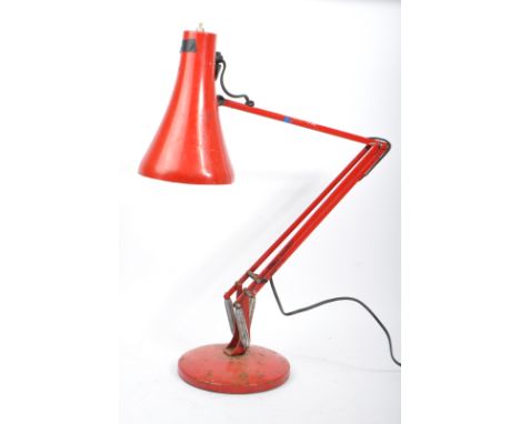 A mid 20th Century Anglepoise desk lamp in red colourway. The lamp with a rotating stem and shade, a push button switch atop 