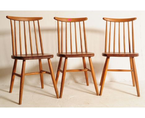 A set of three retro mid 20th century teak spindle back dining chairs. The chair shaving shaped top raised over spindle backs