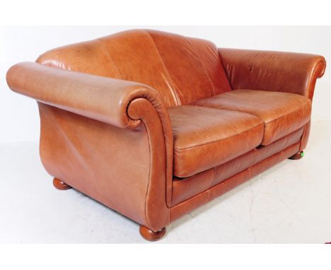 A contemporary Chesterfield / club  leather sofa settee. Raised on bun feet with arched barrel arms and moustache shaped back