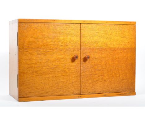 A mid 20th century vintage teak and plywood medicine wall cabinet fitting. Comprising of twin hinged doors with ball pull han