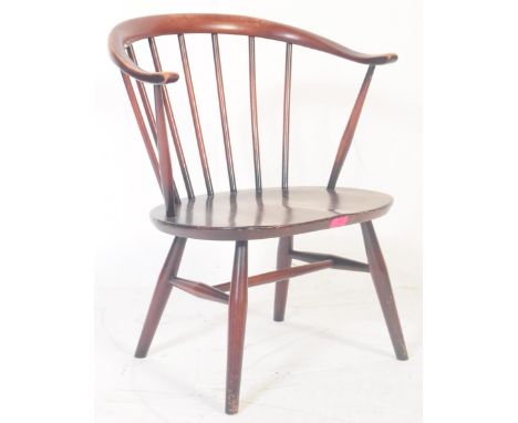 Ercol - A retro 20th century Ercol dark beech &amp; Elm nursing chair being raised on turned legs with elbow rests, saddle st