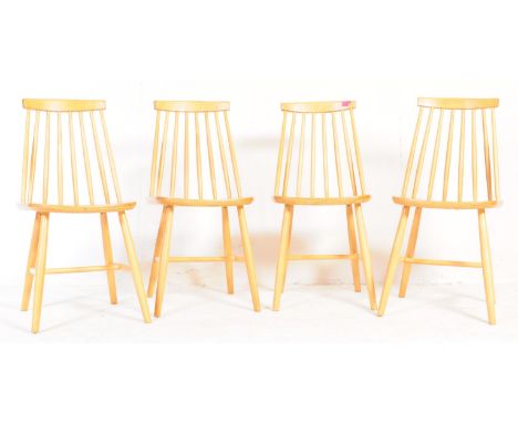 A set of four contemporary Ercol style dining chairs. With single horizontal slat with spindle back support on a saddle seat,