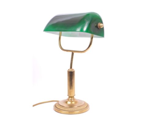 A vintage 20th century bankers office table lamp light. Having a green glass swinging shade, with brass reeded support on a s