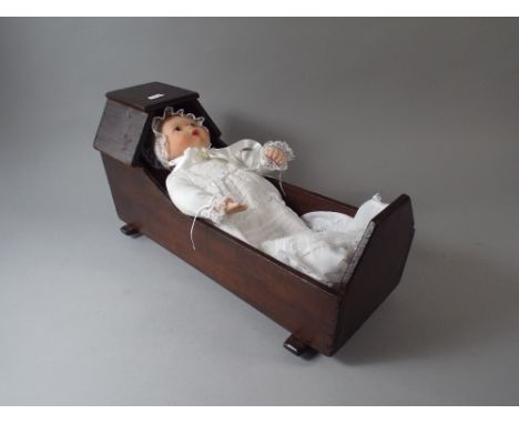A Victorian Stained Pine Dolls Cradle Containing Modern Ceramic Head Doll.