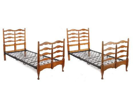 A pair of Heals &amp; Son oak single beds, with arched ladder backs and turned uprights on block and cabriole legs, 93cm wide