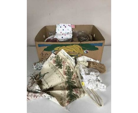 Three boxes of material, lady's clothes, tie backs etc 