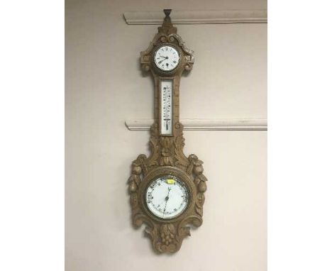 An Edwardian carved oak combination barometer/thermometer/clock