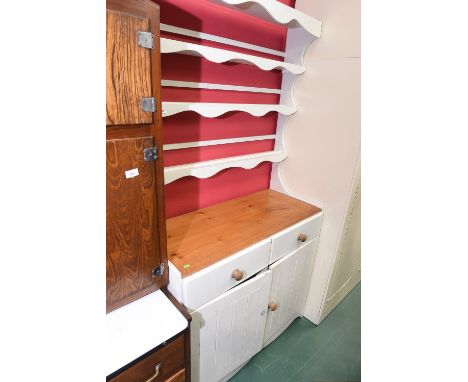 A painted pine dresser with plate rack above two drawers and pair of panelled doors enclosing a shelf.