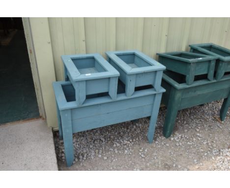a large painted wooden plant trough; tog. with two similar smaller troughs