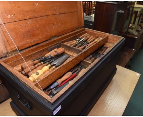 A 19th century painted pine blanket box converted to a tool chest and containing vintage planes, saws, chisels, set squares a