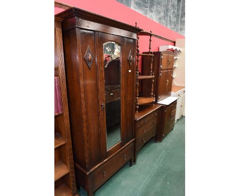 An oak wardrobe, circa 1920 with looking glass panelled door and single drawer below together with matching dressing table wi