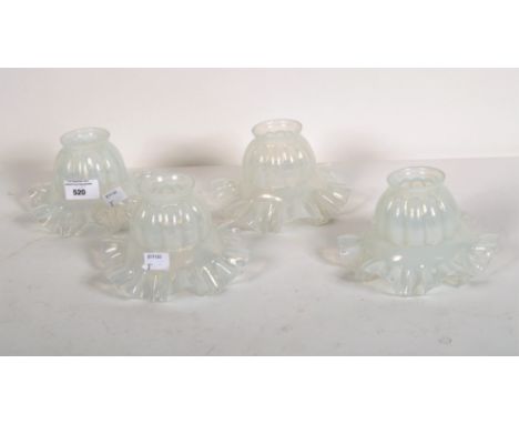 A set of four early 20th century glass light shades, with opaque glaze and fluted rims, height 10cm