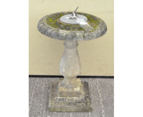 A stone sundial, the metal dial mounted on a baluster column support, 68 cm high 