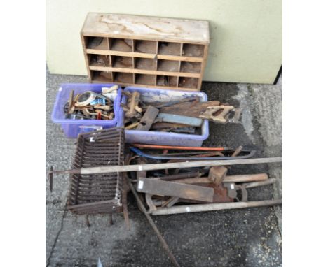 A quantity of tools, including saws, hoe and other items, a fire grate and a wooden storage unit