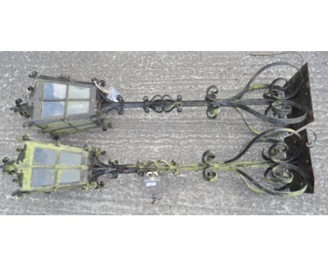 A pair of garden 'lamp posts', with glazed lamp shades on scrollwork bases, 125 cm high 
