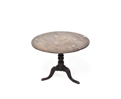 An early 19th century oak tilt top table, of circular form, raised upon turned tripod support, 66cm x 90cm