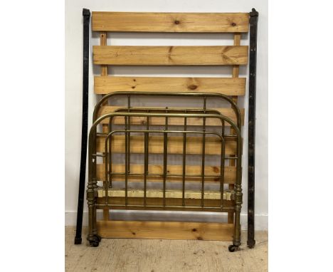 A Victorian brass arched Scottish double size bed with spar ends and wooden base complete with original brass caps and black 