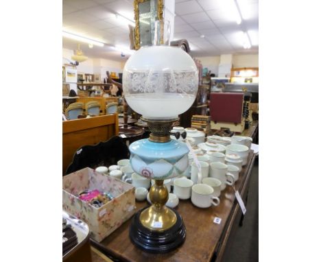 A Victorian oil lamp with etched glass shade.